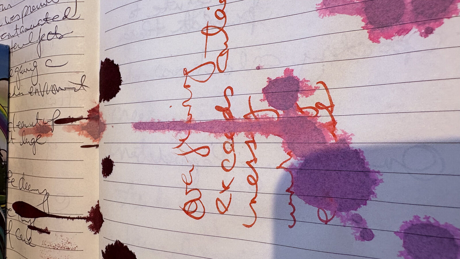 A notebook page turned on its side, covered in pink and purple ink blooms; sideways red handwriting reads 'everything exceeds containers' across the page.